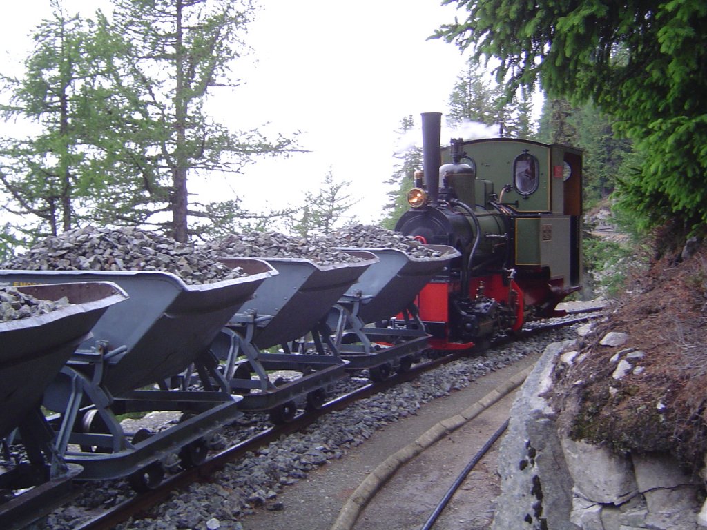 2 ft gauge steam engine  Liseli  (Jung No 1693, built 1911) in service on the high alpin panoramic railway of  Parc d'Attractions du Chatelard (VS)  in Switzerland.
A heritage train with ballast wagons, like 80 years ago. The weather was dark and rainy, because of that the image is not the best. But the scenery give nice impressions. 19 June 2009