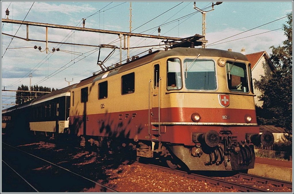 SBB Re 4/4 II in the TEE color by a stop in Grenchen South. 
04.08.1984 / scanned picture