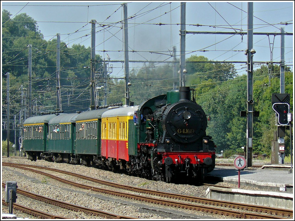 The PFT-TSP P8 steam locomotve 64.169 is hauling its historical train into the station of Ciney on August 16th, 2009.