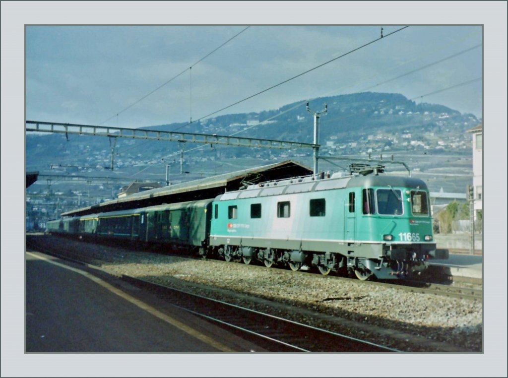 The SBB Re 6/6 11665 in the test SBB-Cargo color with a fast train in Vevey in the early 2000.