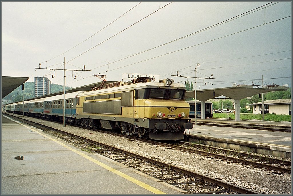 The SZ 363 004 with the international overnight train from Zurich to Zagreb - (Beograd) by the stop in Ljubljana. 
(autumn 1996/ scanned negative)