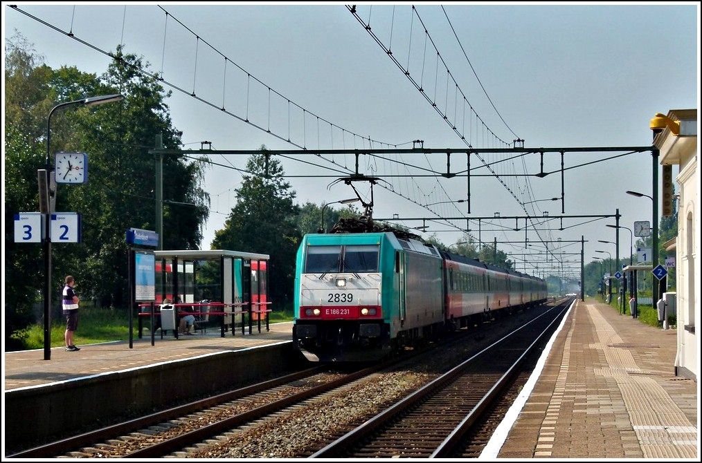 The TRAXX 2839 is hauling the IC Antwerpen - Amsterdam through the station of Oudenbosch on September 3rd, 2011.