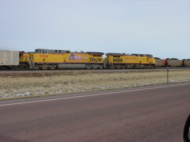 UP 1266 & 5958 pull an empty coal train past a full train near Bill, Wyoming on 10 Nov 2003.