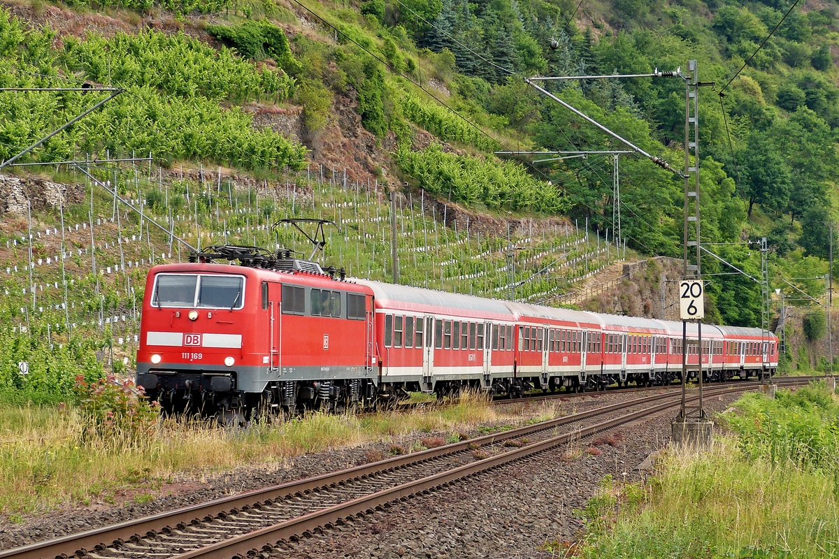 . 111 169 is hauling n-waggons into the station of Kattenes on June 21st, 2014.