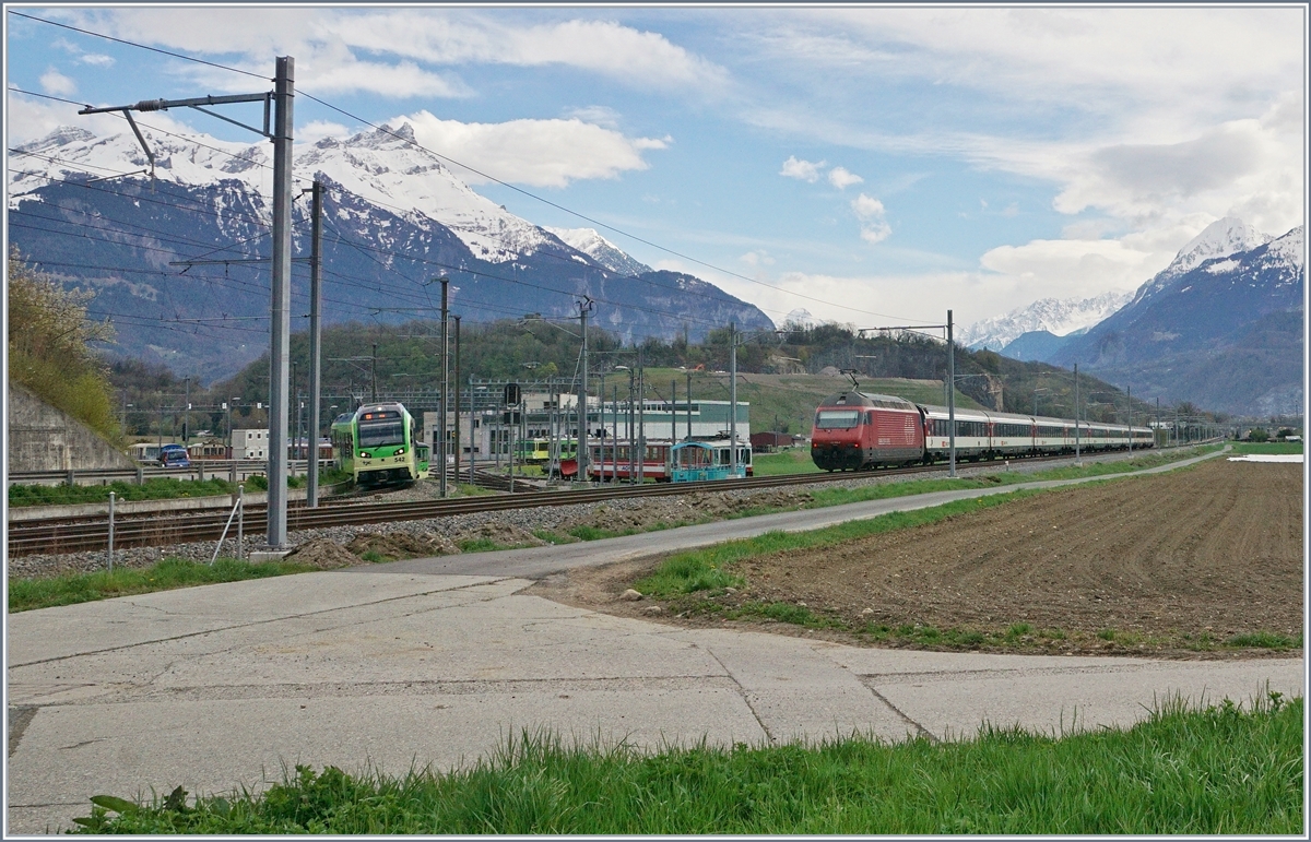 A SBB Re 460 with his IR on the way to Brig and and a TPC GTW SURF Beh 2/6 on the way to Aigle by the TPC Depot. 
12.04.2018