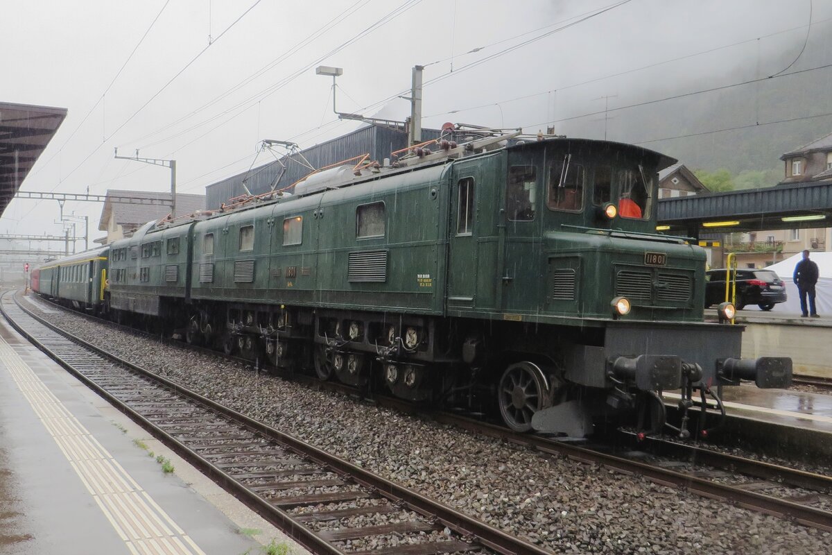 Ländilok 11801 stands at Erstfeld with an extra train in the pouring rain on 19 September 2021.