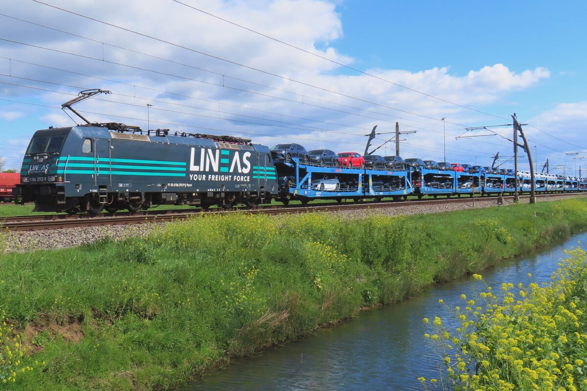 Lineas 186 292 hauls an automotive train through Valburg on 18 April 2024.