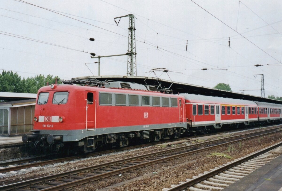 On 26 May 2004 DB 110 162 calls at Köln-Deutz. From 110 288 CLass 110 got more streamlined cabs that reminded some to the fold in a flat-ironed trousers ('Bugelfalten') where the 110 101-287 had more straight cabs ('Kastenzehner') like 110 162 in this photo.