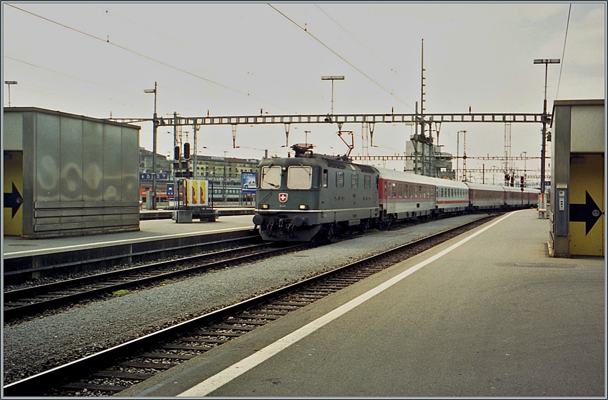 The SBB Re 4/4 11344 reaches Zurich main station with a DB EC. The locomotive was still painted green, but has square headlights.

Analog image from May 2001