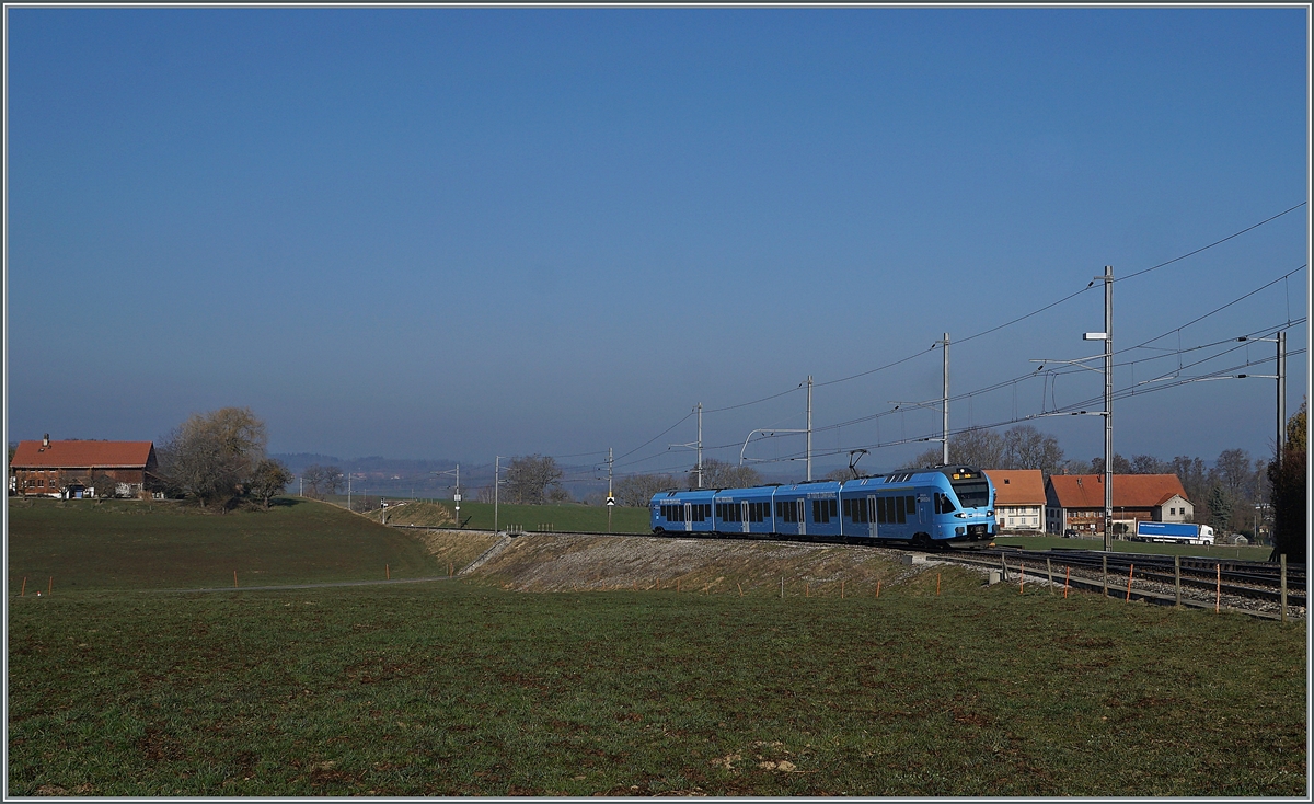 The TPF RABe 527 198 on the way to Bulle by Vuisternens-devant-Romont. 

1. März 2021