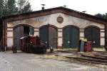 K�f 323 352-5 in front of an old locomotive shed ...