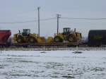 Goods wagons A pair of Caterpillar end loaders are riding high thru the yard at Burlington, Iowa. They are produced in Illinois and these are heading west. 13 Dec 2005.