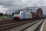 On 19 February 2022 RailPool 186 503 hauls a steel train through Amersfoort under a cloudy sky.