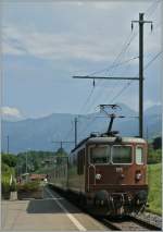 BLS Re 4/4 195 with a local train to Interlaken is leaving Faulensee.
