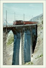 A analog picture with a BLS Re 4/4 and his EC  Monteverdi  to Venezia on the Luogelkinn Bridge by Hotenn (BlS South Ramp).