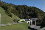 The BLS Re 465 014-9 is traveling with its Golden Pass Express GPX 4069 from Interlaken Ost to Montreux and passes the elegant Bunschenbach Bridge near Weissenburg. October 7, 2023