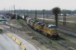 A freight train of the Union Pacific with three engines of different types is arriving in a yard in Houston Texas.