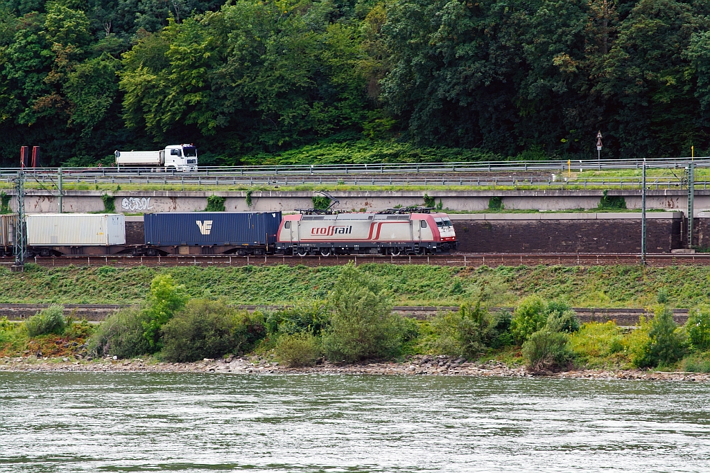 185 591-5 of the Crossrail with a container train, on 11.08.2011,  runs at the left side of the Rhine, across from Unkel, towards Kln.