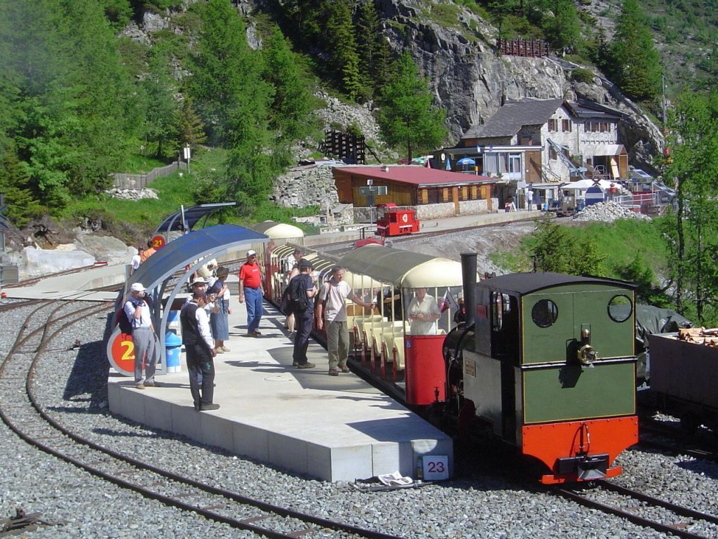 2 ft gauge steam engine  Liseli  (Jung No 1693, built 1911) in service on the high alpin panoramic railway of  Parc d'Attractions du Chatelard (VS)  in Switzerland.
In the station  Les Montuires  on 1'800 metres about sea level. Behind a battery engine (normally used for regular trains) enjoying the sun. The building is the mountain side station of the world's record holding most steep funicular with 2 cabin traffic (maximum 84% gradient). 22 June 2008