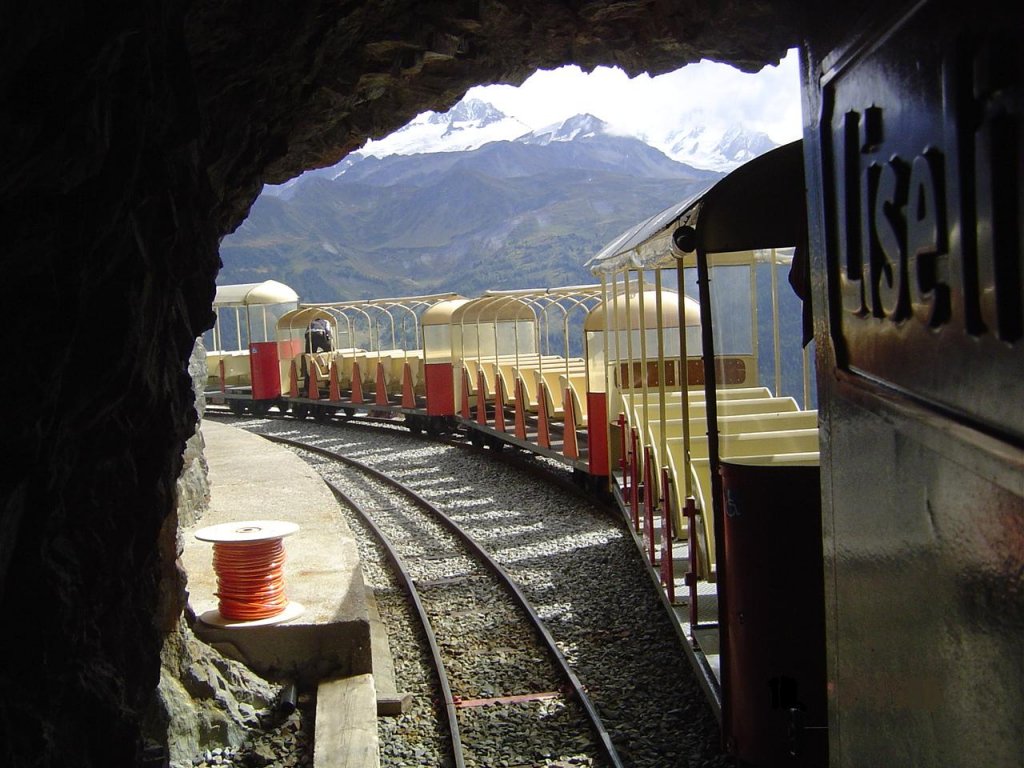 2 ft gauge steam engine  Liseli  (Jung No 1693, built 1911) in service on the high alpin panoramic railway of  Parc d'Attractions du Chatelard (VS)  in Switzerland. Shunting run in the station  Pied du Barrage . The mounth of tunnel No 5 arounds the scenery. Picture was taken from locomotive platform. 16 Sept 2006