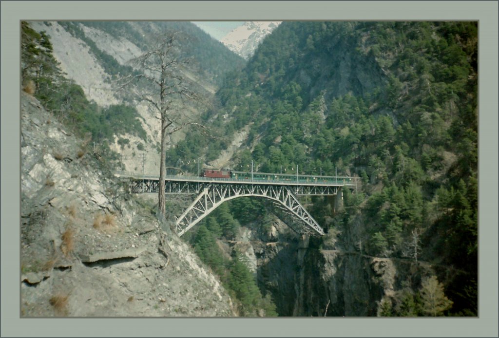 A BLS Re 4/4 with a fast train of the Bietschtal Bridge. 
Spring 1993