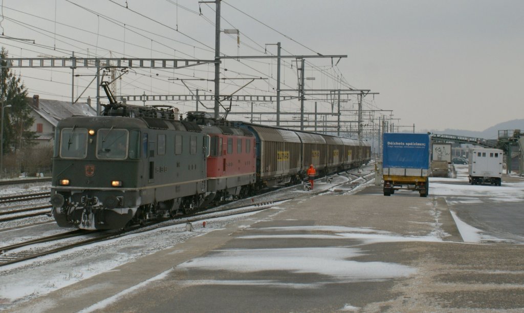 A green and an red Re 4/4 II with a Cargo train in Chavornay. 
08.01.2010 