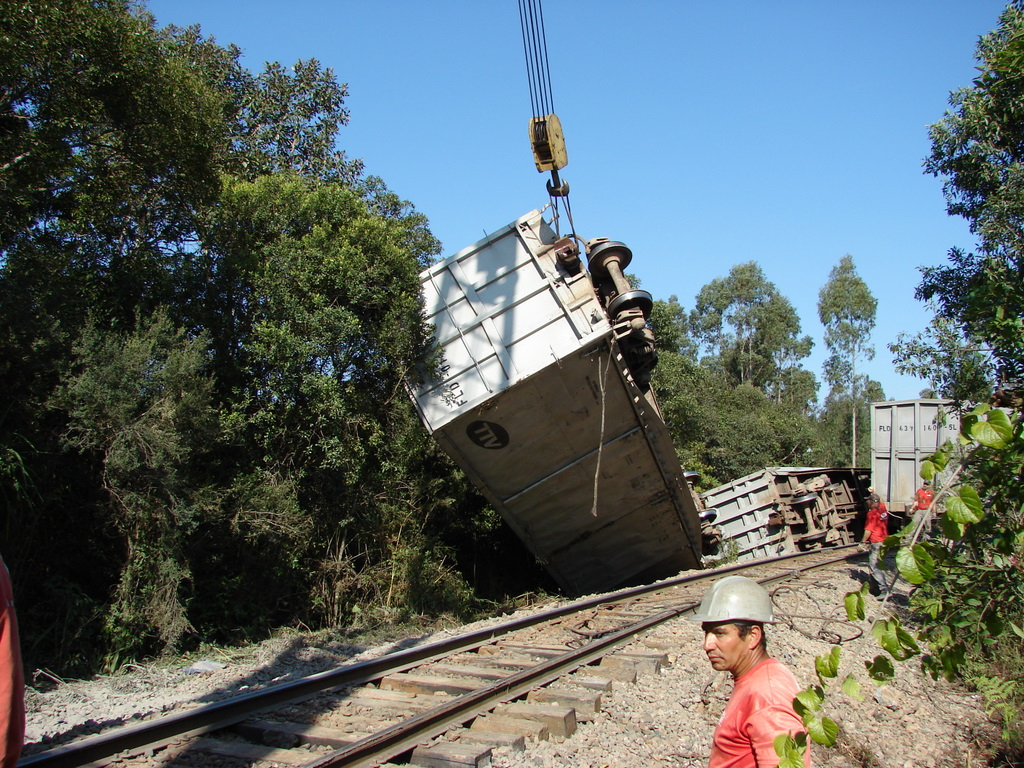 A train derailed above Curitiba. with a heavy crane, the cars are lifted back onto the rails.