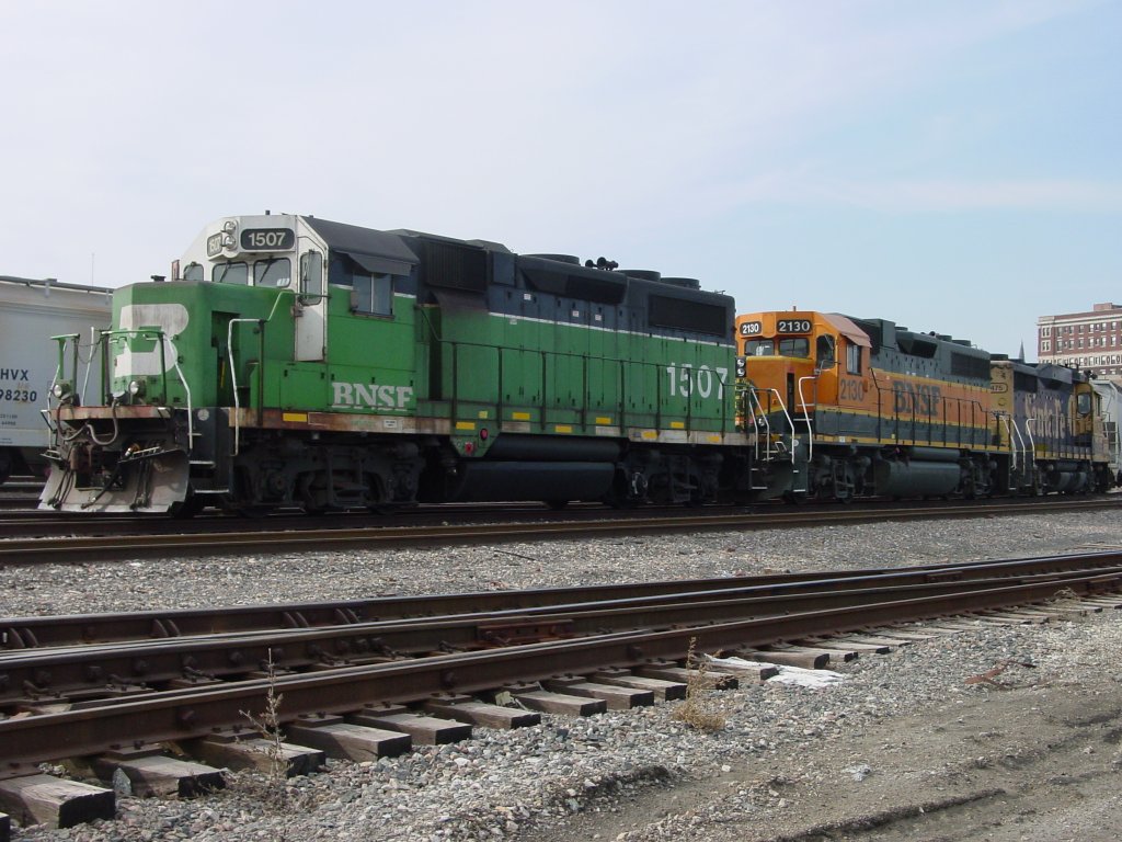 An old Burlington Northern unit 1507 remarked with BNSF lettering on the cab sits with a BNSF Heritage I paint scheme lok 2130 and a Santa Fe unit ? 2475 ? with the beginning of a freight train that would later go to Galesburg, Illinois. 27 Feb 2006. Hotel Burlington is at the right.
