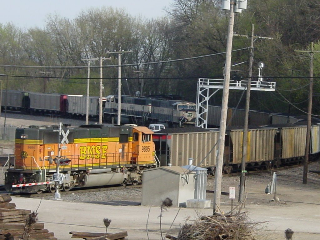 BNSF 9895 pushes a loaded coal train onto the  K line  which follows the Mississippi River for the next 5 miles. Coal train is heading to the power plant south of Burlington, Iowa. At the same time a pair of SD70MACs pull an empty train across the bridge on 9 Apr 2005.