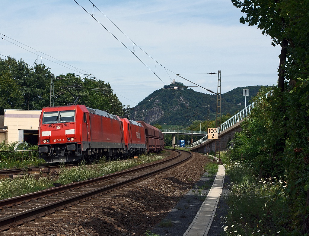 Electric locomotives 185314-2 and 185213-6 pull an ore train, at 11.8.2011 on the right Rhine track, at Rheinbreitbach, heading south. In the background is the Drachenfels.