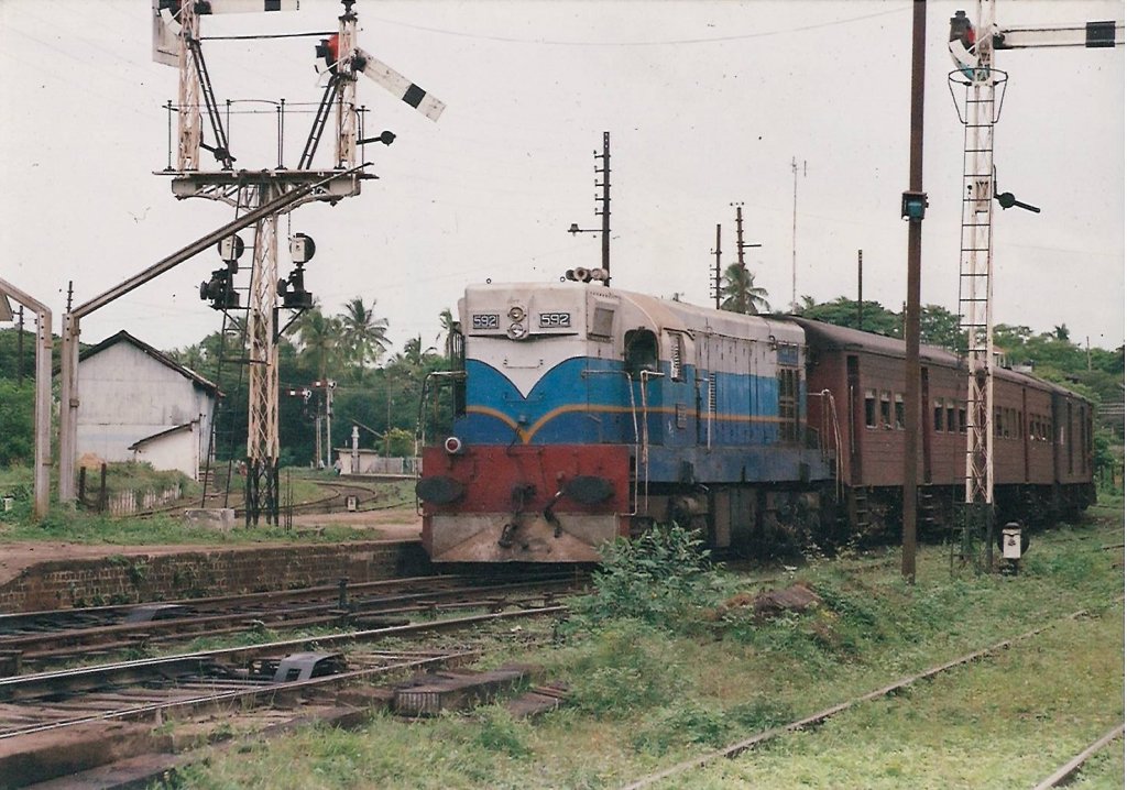 EMD G12 Class M2 592 “ Nova Scotia” is  ready for its departure from Mahawe Junction to the terminus in Trinco which is in the east coast. Semaphore home signal is clearly visible with its arm down to say “all clear”.  Semaphore signalling is still been used in some parts of the country including  the main line. this was captured in Aug 2012. 