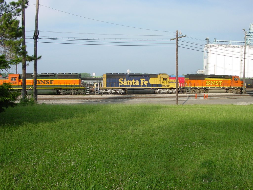 Here at the Burlington, Iowa depot sit 3 different paint schemes. On left is the BNSF Heritage One scheme (orange with green letters) number 7801. In the center is Santa Fe 6335 with BNSF painted at the bottom of the cab. On right is BNSF Heritage TWO (orange with yellow letters) number 116. 11 July 2005.