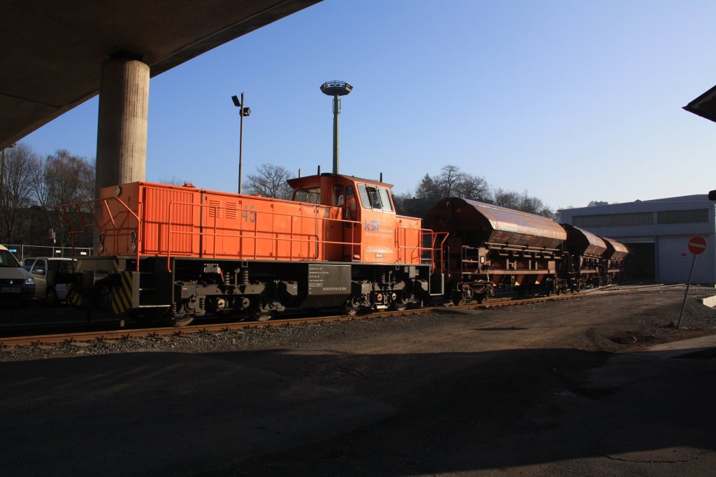 Lok 45 (MaK G 1204 BB) der  Kreisbahn Siegen-Wittgenstein (KSW) schiebt am 31.01.2011 drei Gedeckte Schttgutwagen in die KSW Lok- und Werkstatthalle.