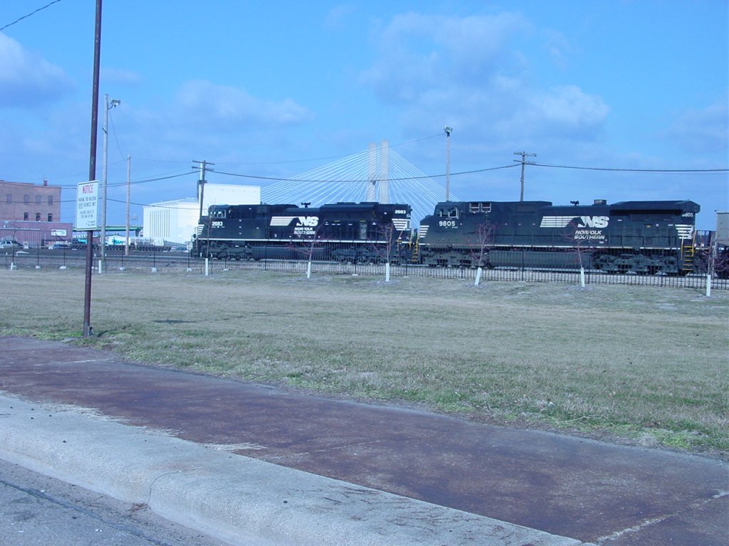 Norfolk Southern is a rare site in Burlington, Iowa. Here NS 2683 & 9805 pull an empty CEFX coal train thru the yard and approach the Main Street crossing. The auto bridge over the Mississippi River is visible behind the loks. 6 Mar 2006