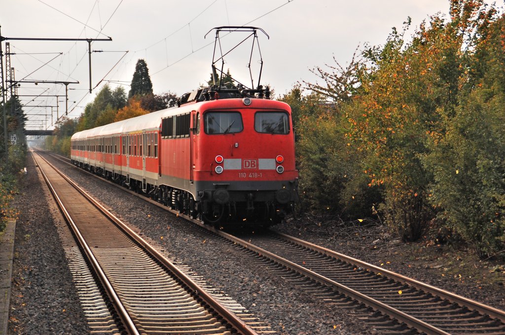 On that grey and rainy afternoon the class 11o 418-1 passes straight the station Bttgen/Germany by, with it's supporttrain at Line RE4 to Aachen. The main trains at the RE4 line build by 5 doubbledecker coaches and an class 111 or 112 locomotive. October 10th 2011