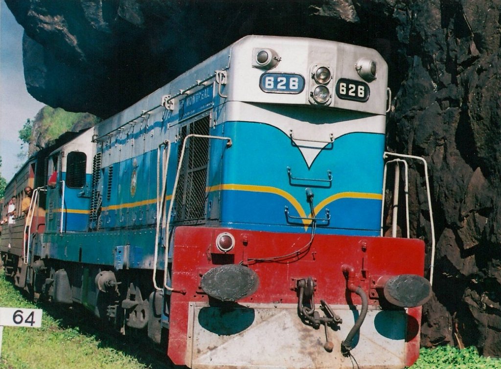 Passing Lions Mouth, train passes through an overhanging rock on the way to Kadugannawa on 6th 1uly 2012. The train is negotiating a bend and that is the reason for its tilt  towards the cliff. These engines were gifted by the  Canadian government and all were named with different provinces. This was named “ Montrial”.  