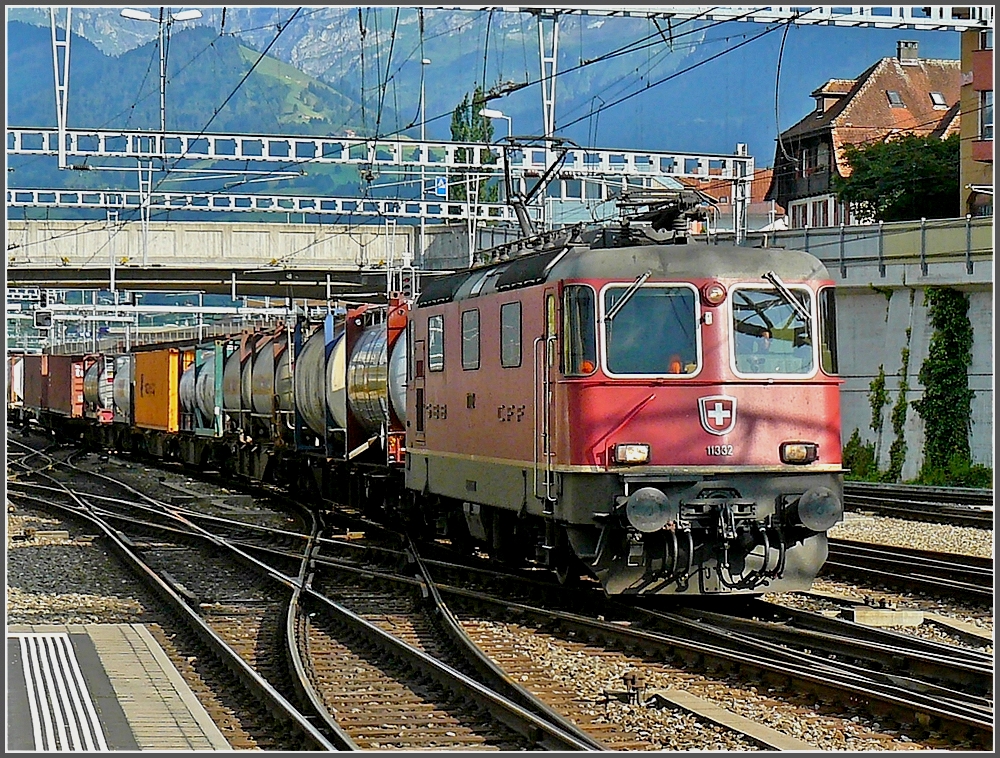 Re 4/4 II 11332 is hauling a goods train through the station of Spiez on July 29th, 2008.