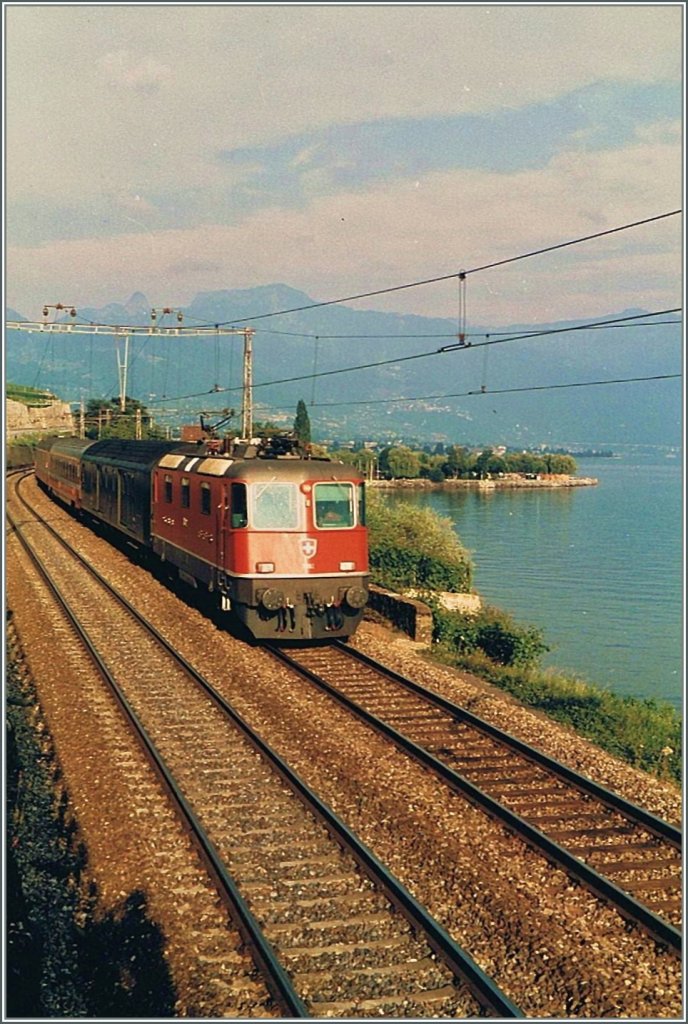 Re 4/4 II with an EC from Milano by St Saphorin in the summer 1985. 
(scanned picture)