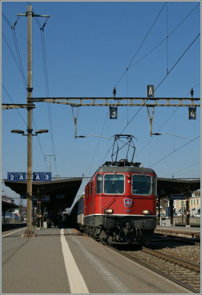 SBB Re 4/4 II 11135 with a RE from Geneva to Lausanne by the stop in Rennes VD. 
02.03.2012