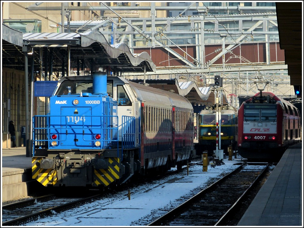 The CFL Cargo shunter engine 1104 is hauling two SNCB wagons through the station of Luxembourg City on February 1st, 2012.