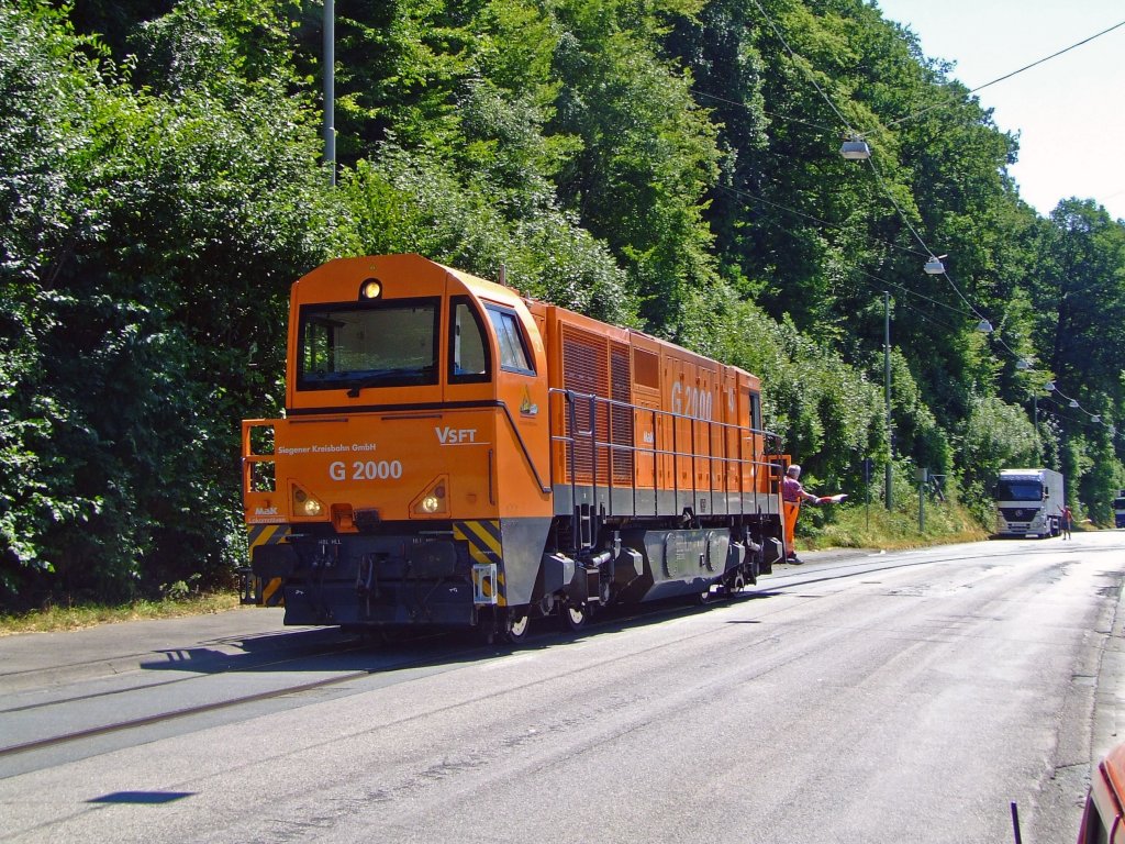 The Mak G 2000 (Lok 43) of the Kreisbahn Siegen-Wittgenstein moves in Siegen-Eintracht on the road Eiserfelder Street (Siding of the tube factory) on 19.07.2006. The track has since been re-laid beside the road.