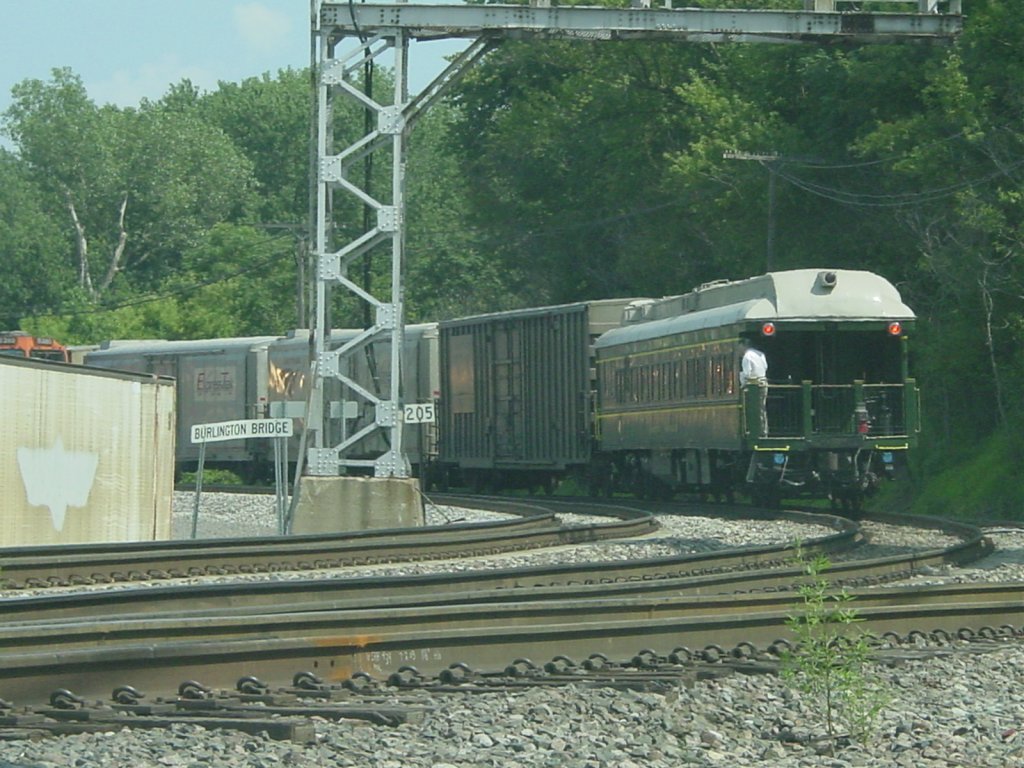 The passenger is stretching to see the Mississippi River as his private coach is about to enter the bridge. Private coaches are rare these days.