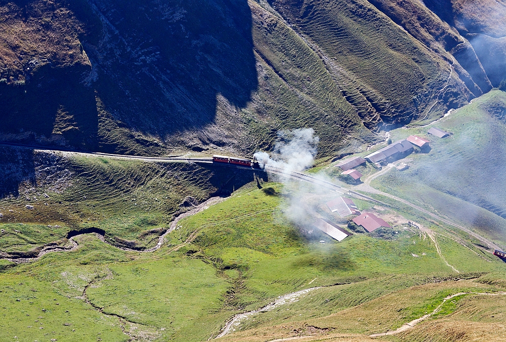 The steamer rises almost effortlessly, but smoking up the mountain. The coal-fired BRB 6 runs on 01.10.2011 to the Brienzer Rothorn up here at the crossing point the Oberstaffel(1828 m above sea level).