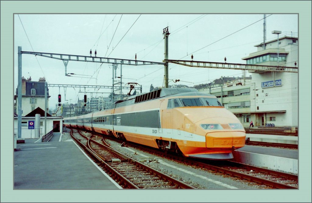 The TGV 117 is laving Lausanne on the way to Paris. In the first times, the TGV color was orange. 
February, 1998/scanned negative