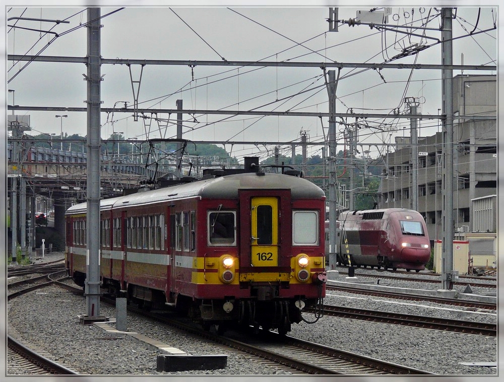 Two red trains are entering at the same time into the station Lige Guillemins on June 28th, 2008.