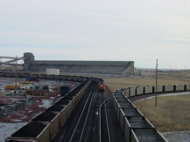 Two trains are being loaded, one BNSF, one UP, while another UP heads off on the staging track to the right. Thunder Basin Coal Co. near Wright, Wyoming 10 Nov 2003.