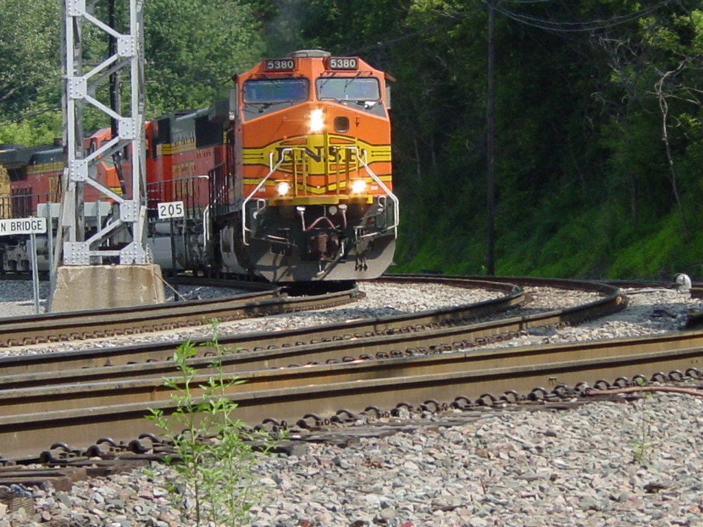 Westbound BNSF 5380 leads a train off the Mississippi River bridge, around the curve and past the 205 mile marker in Burlington, Iowa on 30 July 2003.