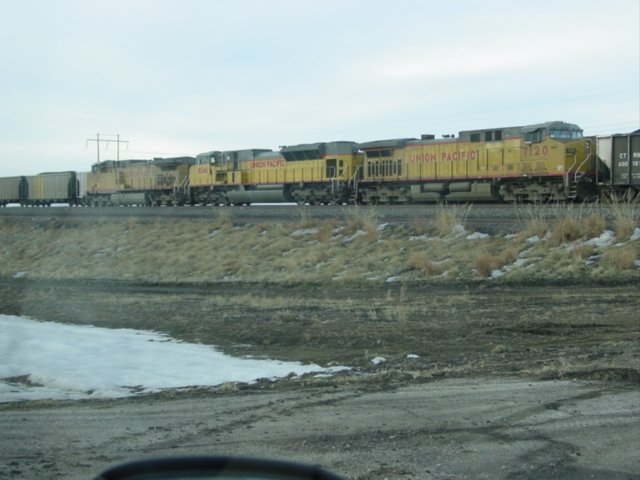With miles and miles of staging track, 4 and 5 wide, Bill, Wyoming has more empty coal cars than almost any place on the planet. Here UP 7120 and two other loks pull a loaded coal train past the miles of empties.