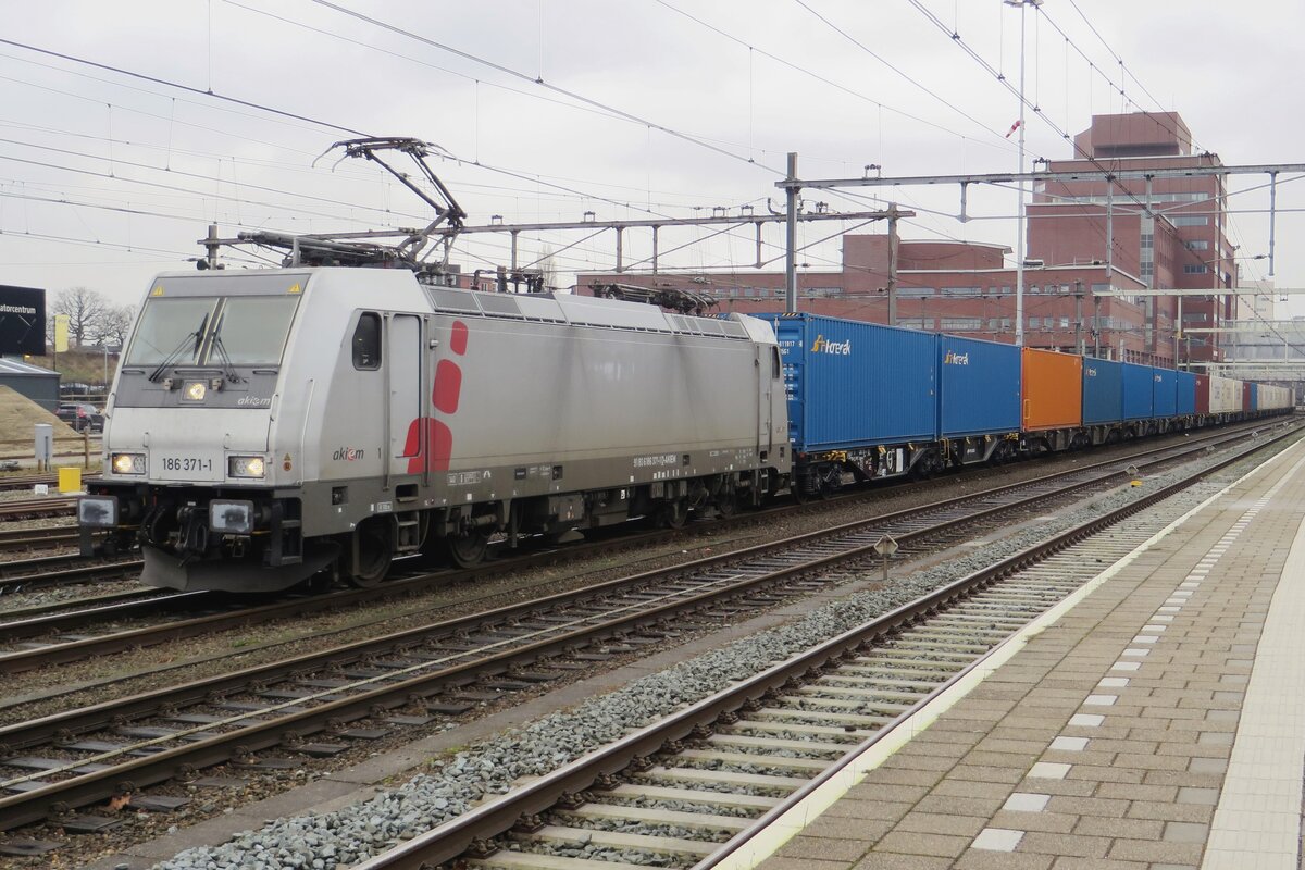 Akiem 186 371 hauls a PKP Cargo container train through Amersfoort on 3 February 2022.