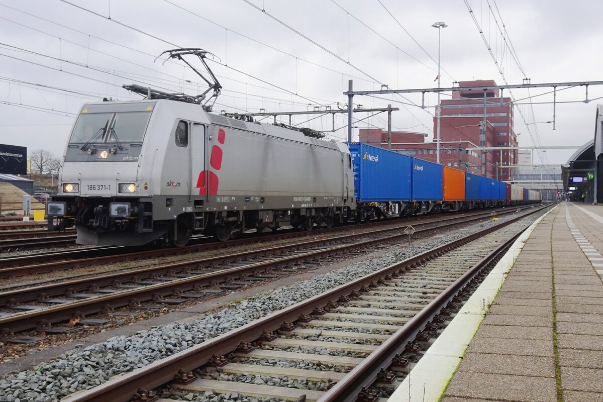 Akiem 186 371 hauls a PKP Cargo container train through Amersfoort on 3 February 2022.